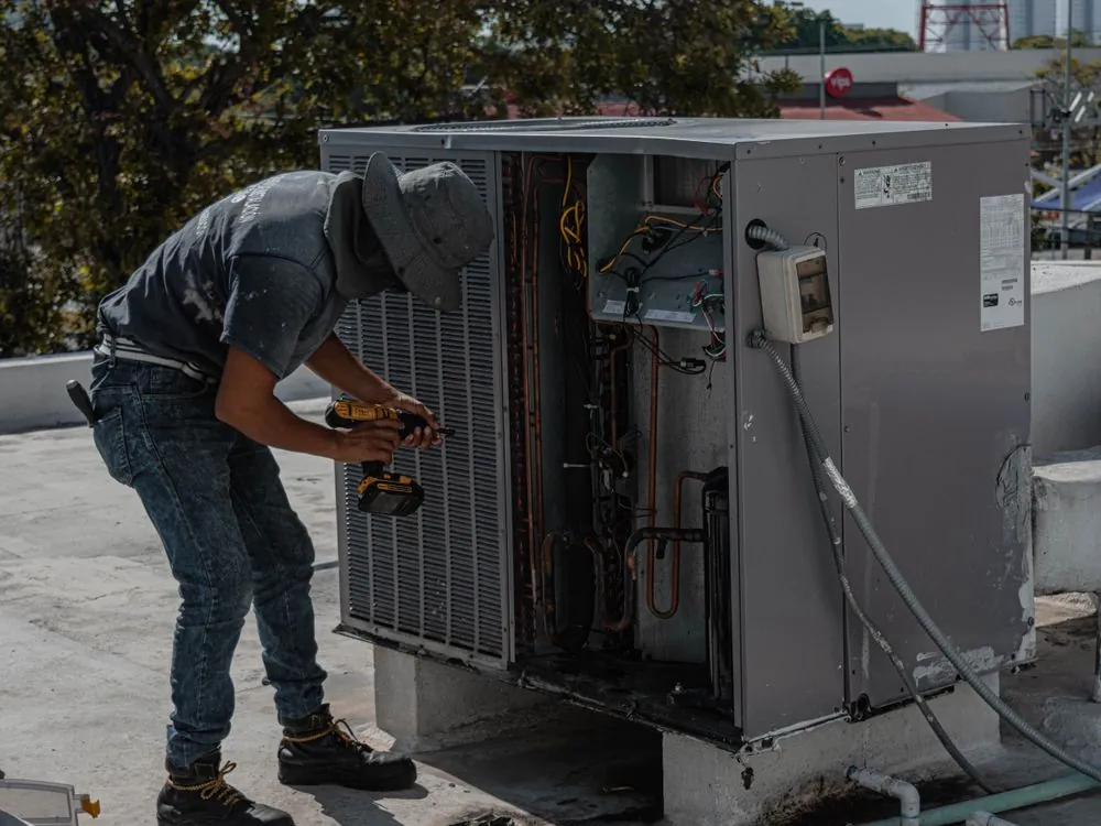 Técnico fazendo reparo na condensadora do ar-condicionado
